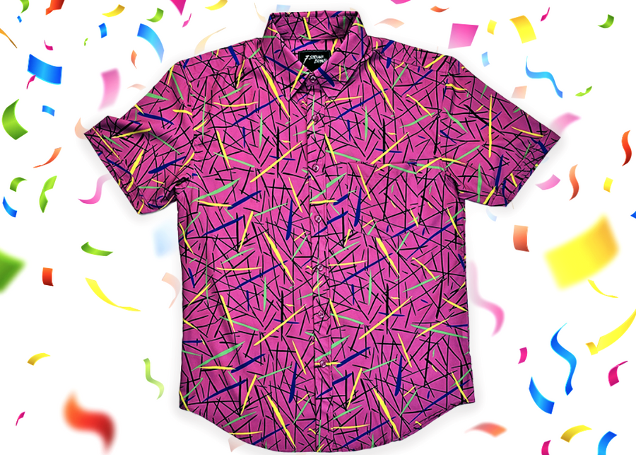 A full, centered view of the 7-Strong adult "Strongfetti" button down, a bold pink shirt featuring black, yellow, lime green, and navy blue scratches that appear like confetti falling from the sky. The shirt is featured on a white background with colorful falling confetti.