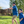 Load image into Gallery viewer, A father and son modeling of the adult and youth 7-Strong &quot;Paper Planes&quot; button down shirt - featuring various sizes and designs of paper airplanes, some with dotted trails behind them against a royal blue background. Both models are aiming to throw their paper planes. 
