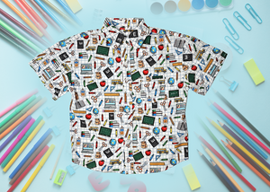 Full centered view of 7-Strong Class act button-down featuring various classroom items such as pencils, rulers, globes, notebooks, apples, protractors, etc against a white graph paper background. Shirt is against a background of school supplies. 