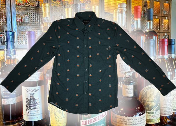 Full display view of the 7-Strong "Straight Sippin'" long Sleeve button down. The shirt is a deep green with black ripples as its background, while the foreground has various drinking glasses with various levels of whiskey, some with ice, others without. The shirt is shown against a background of various whiskies and bourbons on a shelf.