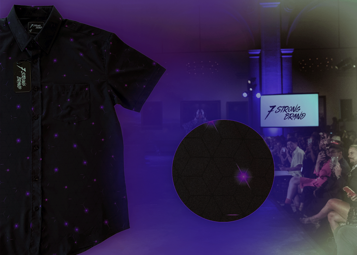 3/4 full view of the 7-Strong "Flux Capacity" short sleeve button down, showcasing bursts and lines of purple light peering through a black grid of cubes. The background is of a fashion show runway in purple hue. Off centered on the right is a detail circle showcasing the shirt's design. 