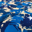 Load image into Gallery viewer, Middle button area close up of the 7-Strong &quot;Service Stars&quot; Adult button-up, featuring blue and creme colored camouflage with white weathered stars throughout.
