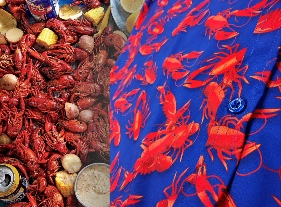 Half shirt view of the 7-Strong Dat Boil shirt, buttons featured most prominently, in deep navy blue with red crawfish patterned throughout overlapping one another. The shirt itself sits on a background image of items from a Crawfish Boil such as crawfish, seasoning, corn, and potatoes. 