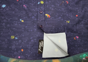 Sweep tag sectional shot of the 7-Strong "Mine Train" adult button up. Shirt is a deep purple with a rock quarry depicting ghosted design showcasing various colors of gemstones and mine train carts throughout. The shirt itself is displayed against a background of a mine shaft and various gems found in buckets. 
