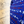 Load image into Gallery viewer, A close up representation of 7-Strong&#39;s 1776 button down shirt, in the middle button region, against a Declaration of Independence background. Shirt is royal blue with stripes of various Americana icons, including the original 13 colonies and revolutionary war items.
