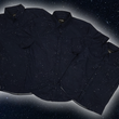 Load image into Gallery viewer, Full view of the long-sleeve, and short-sleeve adult and youth Stargazer button down shirts overlapping one another. A deep navy blue shirt with constellation star patterns throughout. The shirt is displayed against a night sky full of stars.
