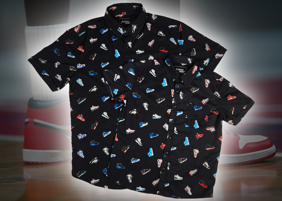 Full view of the adult and youth short sleeve versions of "Got 'Em!," overlapping one another. The button down features various athletic fashion sneakers in an 8-bit format arranged all over a black shirt. The shirt is featured against a background of a basketball player on the court, noticeable sneakers being worn