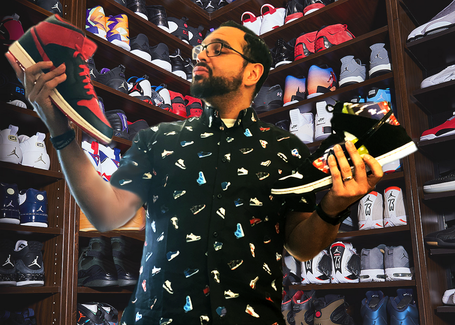 Male model wearing he adult short sleeve version of "Got 'Em!" The button down features various athletic fashion sneakers in an 8-bit format arranged all over a black shirt. Model is looking at two different pairs of choose trying to pick between them in a room full of other sneakers 