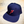 Load image into Gallery viewer, Full, slight overhead shot of the 7-Series trucker hat, showcasing its all navy blue look, back mesh panel, red puffed embroidered 7 with white outline, against a background of the Declaration of Independence.
