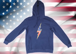 Full view of the navy blue Freedom Bolt hoodie, showcasing a gold outlined 7-bolt with white stars on blue on top and red and white stripes on the bottom. The hoodie is featured on an American flag background. 