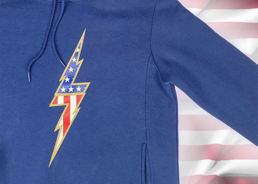 3/4 view of the navy blue Freedom Bolt hoodie, showcasing a gold outlined 7-bolt with white stars on blue on top and red and white stripes on the bottom. The hoodie is featured on an American flag background. 