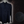Load image into Gallery viewer, Full view of the long-sleeve Stargazer button down shirt. A deep navy blue shirt with constellation star patterns throughout. The shirt is displayed against a night sky full of stars. Bottom right corner shows a detail circle showcasing the constellation design. 
