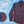 Load image into Gallery viewer, 3/4 full view of the 7-Strong long sleeve &quot;Aye Poppy&quot; button down, featuring an array of red poppys with white sprigs on a deep navy blue shirt. The shirt is displayed against a partly cloudy sky. The bottom left has a detail circle featuring a close up of the design. 
