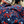 Load image into Gallery viewer, Close up of a male model, at the shoulder, wearing the long sleeve &quot;Aye Poppy&quot; shirt, featuring red poppies and white springs against a deep navy blue background. 
