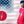 Load image into Gallery viewer, Full view of the red Freedom Bolt unisex tee, featuring a large center placed 7-bolt, outlined in gold, with white stars on blue on top and red and white stripes on the bottom. The shirt is featured on a medium male model against a U.S. flag background. In the bottom left corner, there is a detail circle featuring an up close view of the Freedom Bolt.
