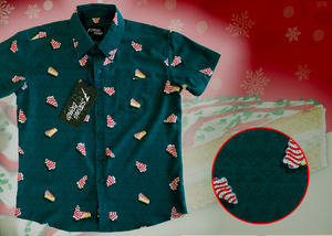 3/4 full view of the 7-Strong "Oh, Christmas Treat" shirt - a green, christmas sweater-like background with columns of various white Christmas tree shaped cakes with red garland, some whole, some bitten. The shirt is displayed against a red, snowing background with a similar parted cake. Bottom right shows a detail circle highlighting the subtle shirt design.
