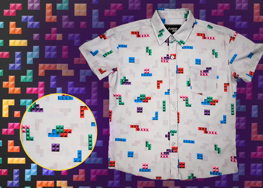 Full view of the 7-Strong Block Party youth button down, featuring various colored blocks of different arrangements inspired by a classic video game, cascading down the shirt against a grayish background featuring shadows of the same shapes. The shirt is presented on a background of similar design.In the bottom left is a detail circle with a close up of the design.