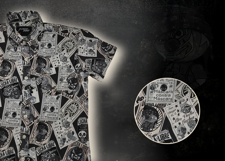 3/4 view of the youth 7-Strong "Cinco de Mayhem" button down shirt. Shirt features black and white posters featuring various created luchadors advertised for matches, all overlapping each other over a black shirt. Shirt is displayed on a black gradient background with some of the characters ghosted in the back. In the bottom right corner is a detail circle highlighting aspects of the design. 