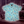 Load image into Gallery viewer, Full view of the 7-Strong &quot;Cheat Day&quot; youth button down featuring various snacks, treats, and fast food features on a light blue shirt. The shirt is displayed against a background of a gym weight rack
