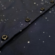 Load image into Gallery viewer, Midsection  view of the youth short-sleeve Stargazer button down shirt. A deep navy blue shirt with constellation star patterns throughout. The shirt is displayed against a night sky full of stars.
