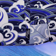 Load image into Gallery viewer, Bottom sweep tag view of the 7-Strong &quot;Let &#39;Er Riptipe&quot; Youth button down shirt, featuring an array of indigo and purple waves with whitecaps all over. The shirt is featured against a purple tinted background of a wave cresting. 
