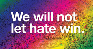 The text "We will not let hate win." in white over a multi-colored rainbow gradient background that is overlaid on a picture of people gathering at a makeshift Pulse Nightclub shooting memorial